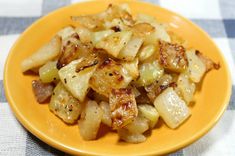 a yellow plate topped with potatoes on top of a checkered table cloth