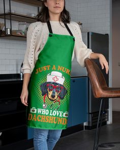 a woman standing next to a chair wearing an apron with a dachshund on it