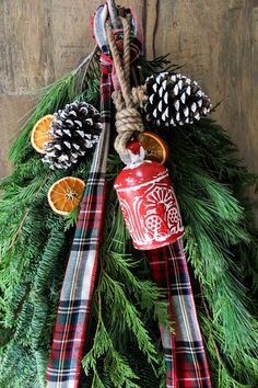 a christmas wreath with pine cones, oranges and other decorations