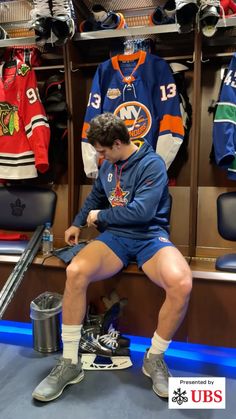 a hockey player sitting in the locker room