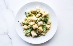 a white plate topped with pasta and broccoli