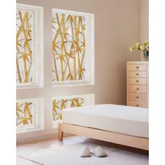 a bed room with a neatly made bed and two windows that have bamboo designs on them