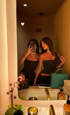 two women taking a selfie in the mirror