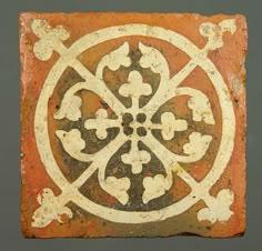 a square tile with an intricate design on the outside, and a circle in the middle