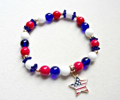 Red white and blue glass and gold seed bead stretch bracelet with American flag theme gold alloy star charm. Bracelet is 7 1/2 inches made of Czech round and flower bead cap beads with gold Czech seed beads. Gold tone bail and charm are lead and nickel free alloy. $1 of purchase will be donated to disabled veterans. I will match donation. Look for earrings in the patriotic section of the shop. Patriotic Round Beads Stretch Bracelet For 4th Of July, Patriotic White Jewelry For 4th Of July, Patriotic White Stretch Bracelet With Round Beads, Patriotic White Stretch Bracelet, Patriotic Blue Star Jewelry, Patriotic Blue Star Shaped Jewelry, Patriotic Blue Star-shaped Jewelry, Patriotic Blue Beaded Stretch Bracelet, Blue Beaded Patriotic Stretch Bracelet