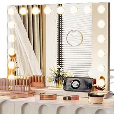 a vanity with makeup and lights on it