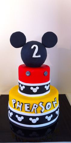 a mickey mouse cake with the number two on it's top and bottom tier