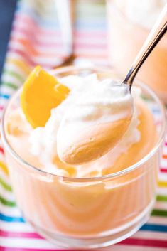 a spoon full of ice cream with lemon wedges in it on a striped table cloth