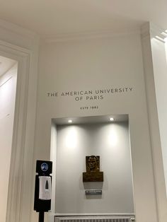 the american university of paris sign is displayed in front of a white wall with an open door