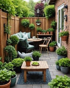 an outdoor patio with potted plants and wooden tables in the center, surrounded by greenery