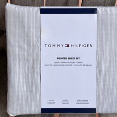 the tommy hilfiger printed sheet set is folded on a wooden surface with clothes pins