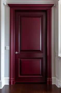 an empty room with a red door and white walls