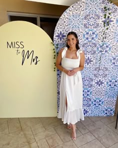 a woman standing in front of a blue and white wall