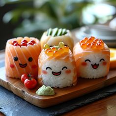 sushi with faces drawn on them sitting on a wooden plate next to other food items