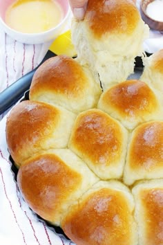 a person holding a piece of bread in front of it on top of a pan