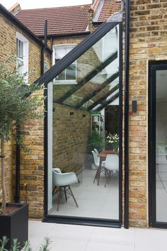 an extension to a house with glass doors on the outside and brick walls around it