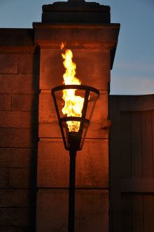 a street light that is on fire in the night time, with flames coming out of it