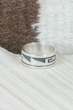 This sterling silver ring was made by Hopi silversmith Timothy Mowa. The inside is stamped sterling.Size: 10Length: 7/8"Width: 3/8"Free shipping on all orders! We ship with USPS and always include tracking. All orders ship within a day of payment.Returns are accepted up to 30 days after you receive your order. Just send us a message. Our shop offers cash back or store credit. The item must be returned in new condition. Artisan Sterling Silver Wide Band Ring, Unique Stamped 925 Thick Band Jewelry, Artisan Sterling Silver Ring With Etched Details, Etched Sterling Silver Wide Band Jewelry, Artisan Sterling Silver Etched Rings, Sterling Silver Etched Wide Band Jewelry, Sterling Silver Engraved Wide Band Ring, Sterling Silver Rings With Stamped 925 And Thick Band, Sterling Silver Ring With Thick Band Stamped 925