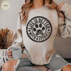 a woman wearing a sweatshirt that says life is better with a pitbull on it