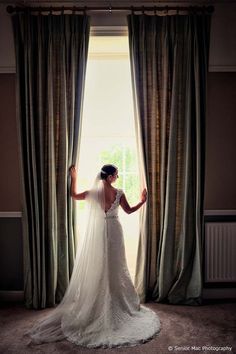 a bride standing in front of a window