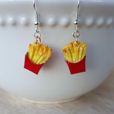 French Fries!  Now Dangle Earrings!  Everyone's favorite side dish to a Cheeseburger!!   Order your food jewelry today! These yummy handmade French Fry Earrings are in a Red Carton and slightly crinkled - just like the real thing! Mmm...  Fun Food Earrings for almost anyone!! The French Fries are handmade of polymer clay and dangle from surgical stainless steel ear wires. The French Fries measures almost 3/4" H. All items are packaged nicely in a jewelry box ready for gift giving! Silly Earrings, Weird Earrings, Miniature Food Jewelry, French Fry, Food Earrings, Funky Earrings, Food Jewelry, Favorite Side Dish, Foodie Gifts