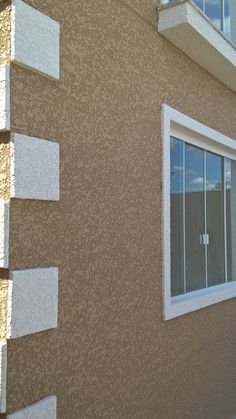 a tan building with white trim and windows on the outside wall is seen in this image