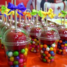 there are many candies in plastic cups on the table