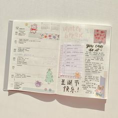 an open planner book with writing on the pages and stickers in chinese characters written across it