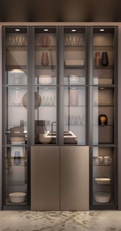 a metallic cabinet with glass doors and dishes on it's shelves in a kitchen