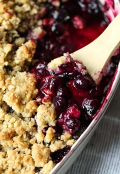 blueberry cobbler in a pan with a wooden spoon