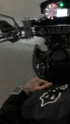 a close up of a person's hand on the handlebars of a motorcycle