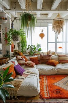 a living room filled with lots of different types of pillows and plants on the wall