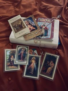 some cards and pictures are laying on top of a bed with a book in the background