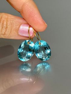 Gorgeous sparkly sky blue aquamarine earrings. The Faceted oval drops are flawless and have a beautiful sky blue color. The drops are attached to 14K18K SOLID GOLD ear wires. The earrings are elegant and have a lux look.  A truly gorgeous pair of earrings.  14K SOLID GOLD ear wires are being used, the ear wire ends are hand-stamped as proof of being 14K solid gold. In addition, extra work was done at the end of the ear wires to prevent any sort of pain or injury while inserting them through the ear lobes. **The 14K WHITE solid gold ear wires are RHODIUM plated to prevent tarnish of the ear wires over time. * Quality: Superb AAA+ FlawlessAquamarine * Carat (26 ct.) * Stone Shape: Facet Oval Shape * The dimension of stones: 18mm X 13mm / 0.7X 0.5 inch  * Metal: 24K Gold Vermeil/ 14K SOLID GO Gold Oval Blue Topaz Earrings, Luxury Oval Blue Topaz Earrings, Blue Oval Topaz Earrings, Blue Topaz Oval Earrings, Oval Aquamarine Light Blue Jewelry, Oval Light Blue Aquamarine Jewelry, Light Blue Oval Aquamarine Jewelry, Oval Topaz Earrings For Gift, Oval Topaz Earrings As Gift