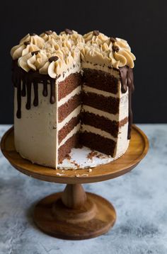 a chocolate cake with white frosting on a wooden plate