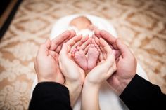 two people holding their hands together to show the baby's foot and hand prints