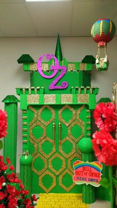 a large green door with a number on it in front of red flowers and other decorations