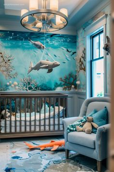 a baby's room decorated in blue and white with a dolphin mural on the wall