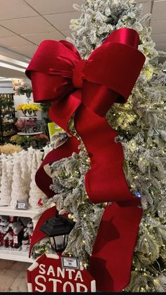 the christmas tree is decorated with red and white ribbons