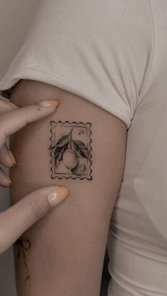 a woman's arm with a stamp on it that has an image of a peach