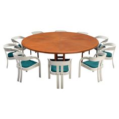 a dining table with six chairs and a round wooden table surrounded by blue cushioned chairs