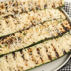 grilled zucchini with parmesan cheese and herbs on a white plate