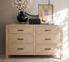 a dresser with flowers and pictures on it