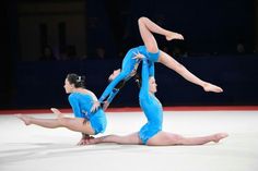 two people doing acrobatic tricks on an ice rink