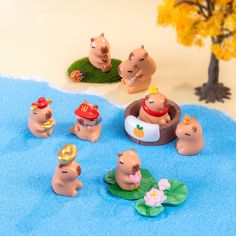 a group of small toy animals sitting on top of a blue rug next to a tree