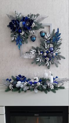 a fireplace decorated for christmas with blue and silver decorations