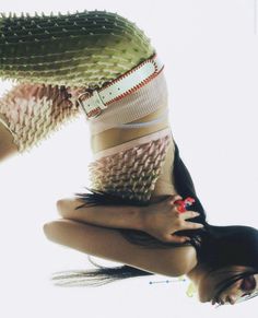 a woman is upside down in the air with her hands on her hips and legs crossed