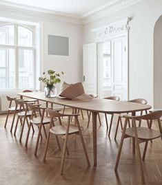 an empty room with wooden chairs and a table