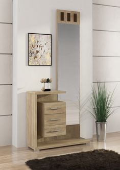 a wooden dresser sitting next to a mirror on top of a hard wood floor in front of a white wall