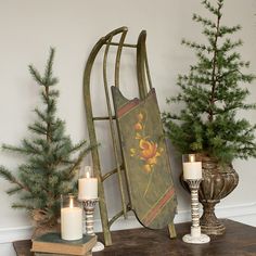 a sleigh with candles on a table next to some christmas trees and other decorations